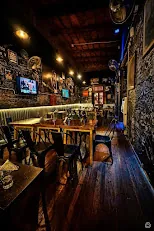Salón de Zeppelin Bar con pantallas y paredes decoradas, Salta